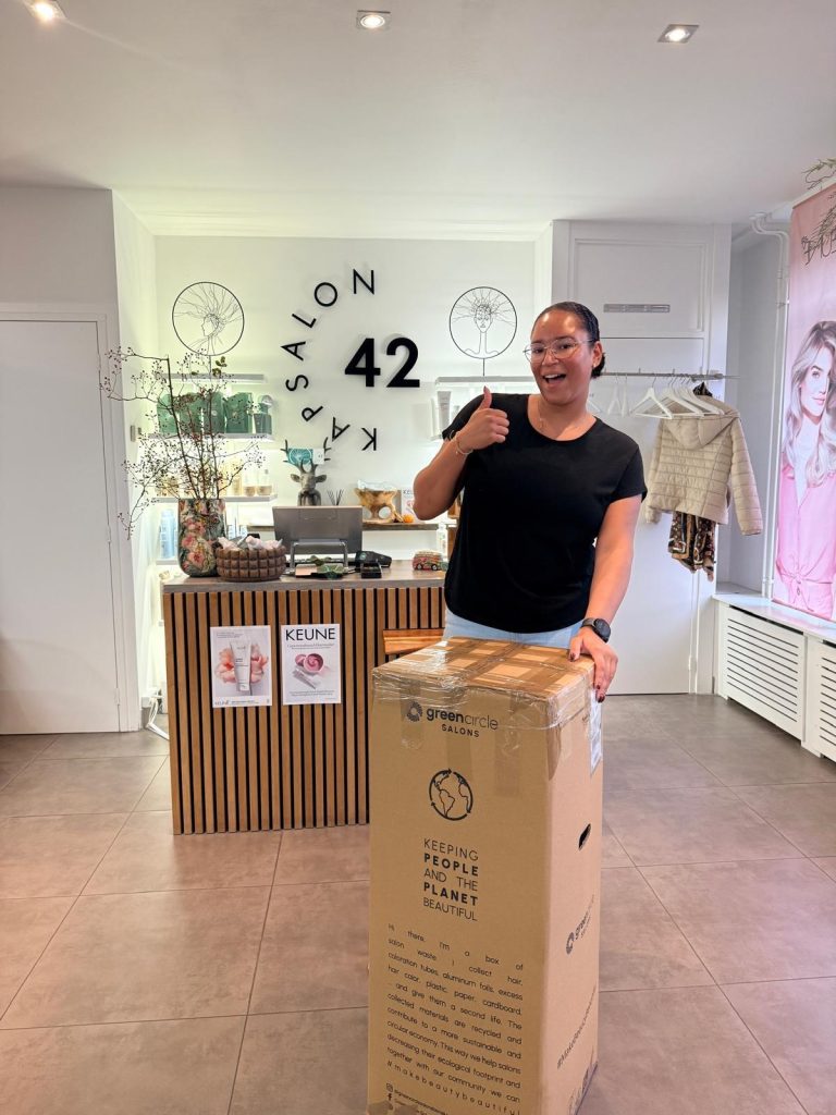 Medewerker van Kapsalon42 met de eerste volle doos kappersafval van Green Circle Salons